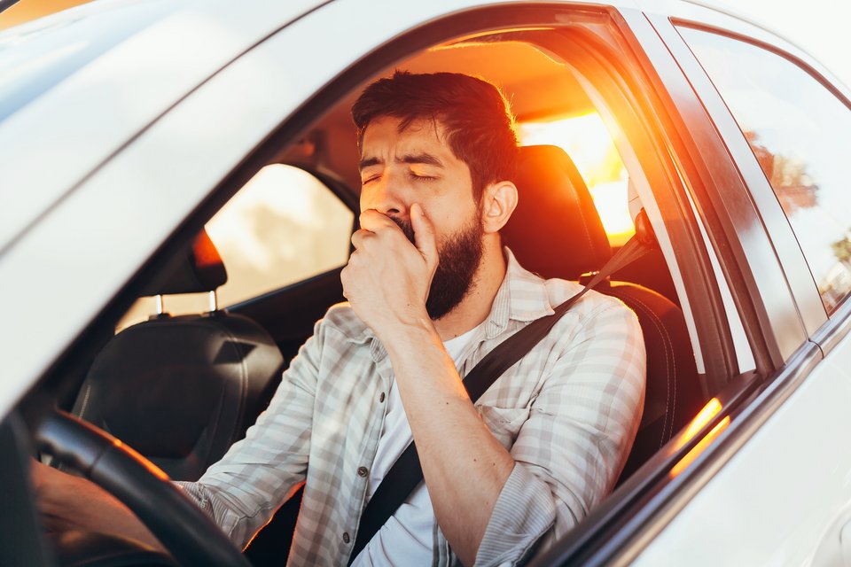 Mann gähnt im Auto