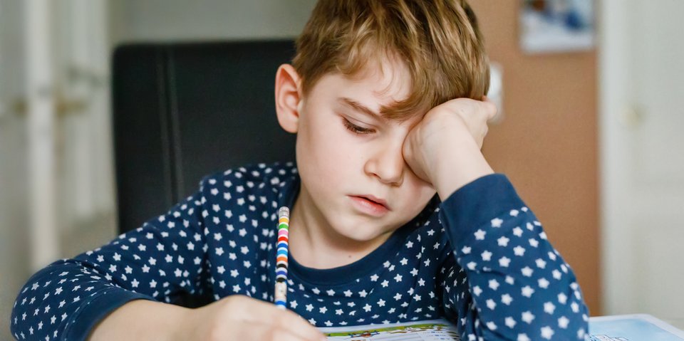 Kind müde bei Hausaufgaben