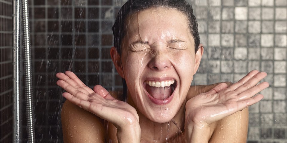 Frau unter der kalten Dusche