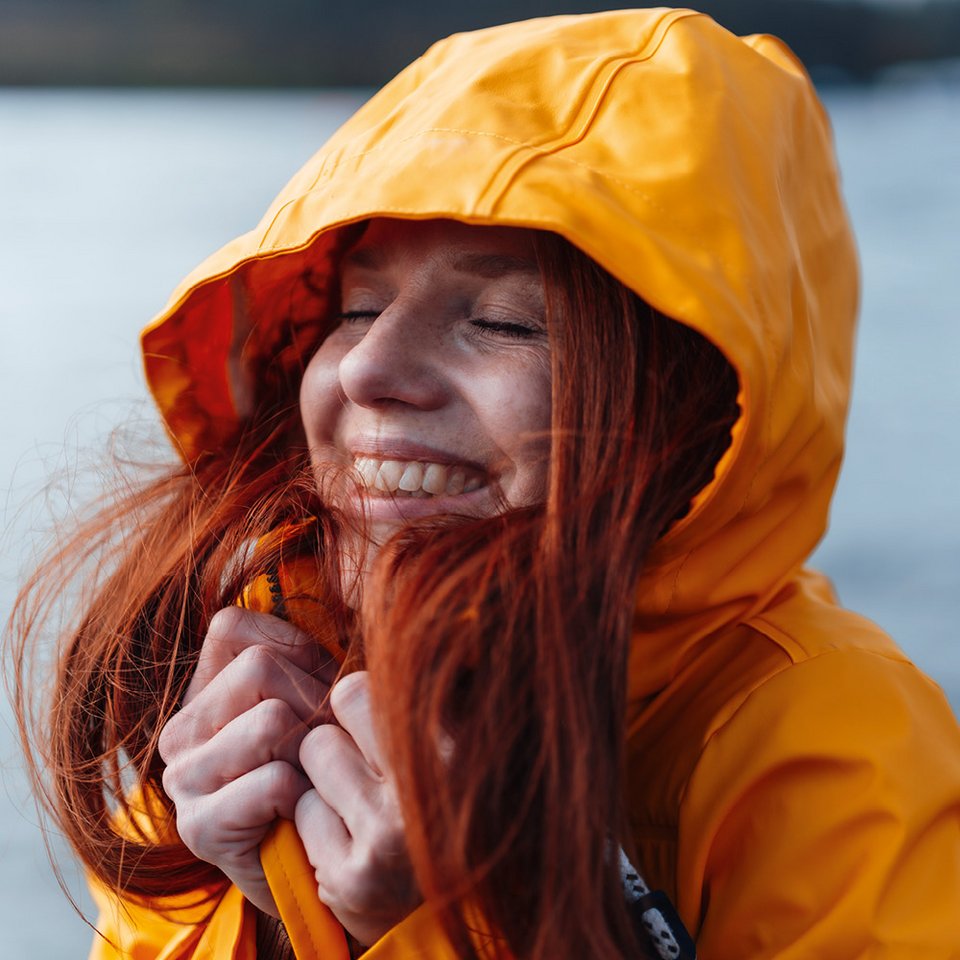 Junge Frau im Regenmantel