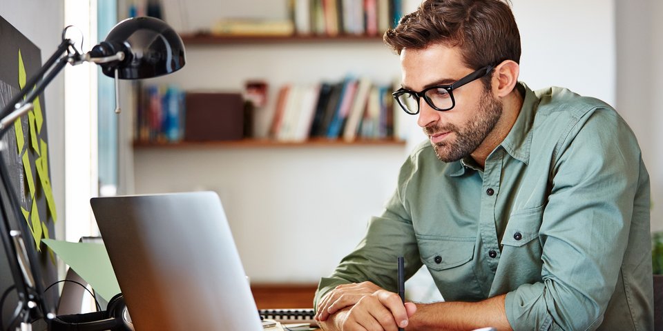 Mann arbeitet am Laptop