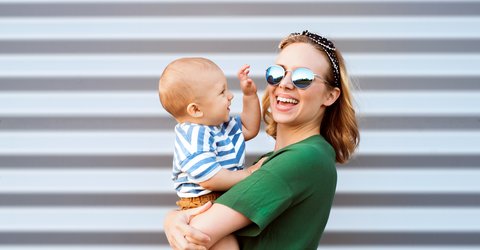 Junge Frau mit Kind auf dem Arm