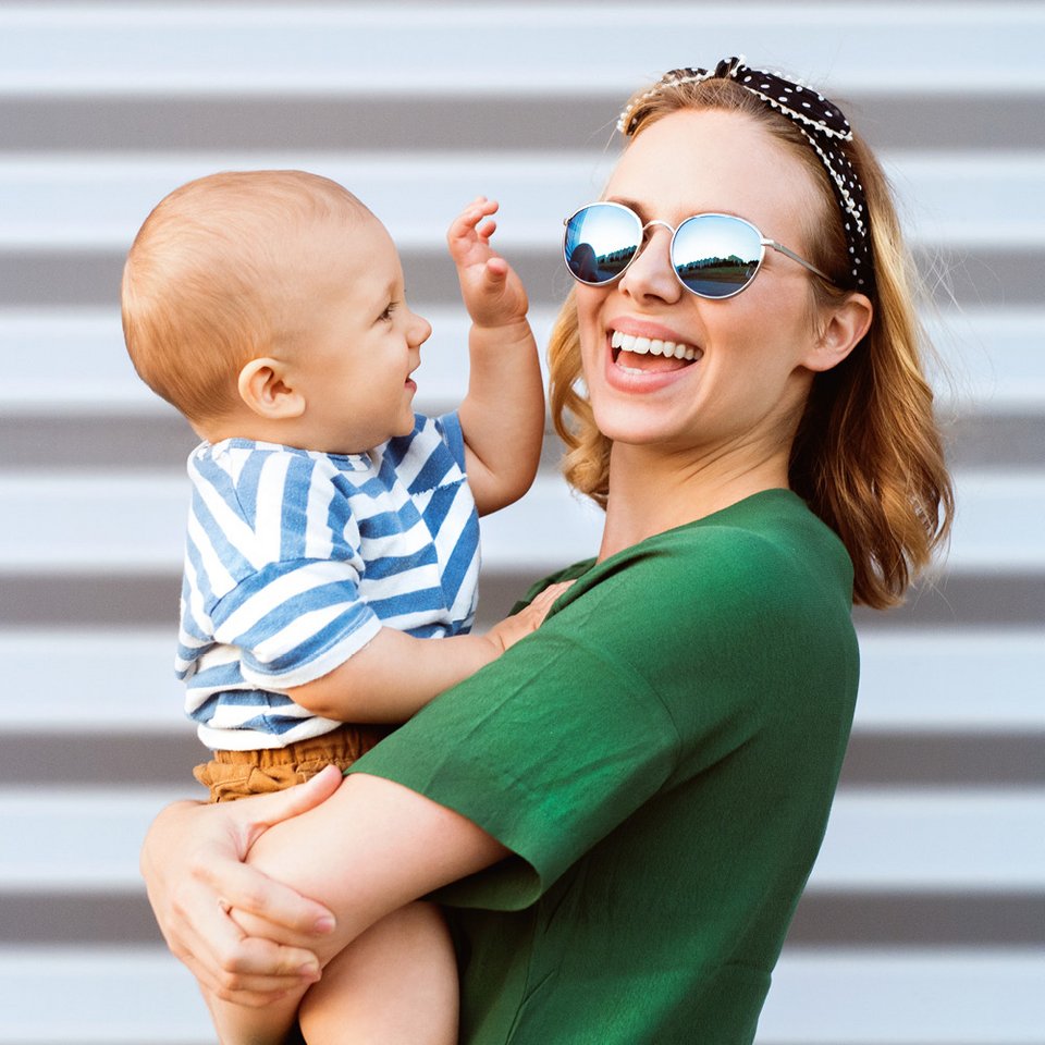 Junge Frau mit Kind auf dem Arm
